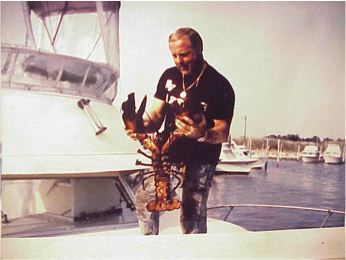 Capt. Stephen W. Bielenda holding lobsters aboard a dive boat