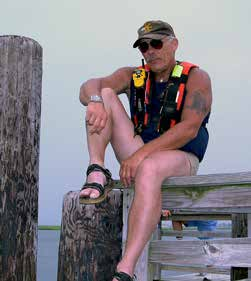 Walt Butch Hendrick seated on a dock
